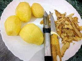 Peeled Potatoes with Knife and Peel photo