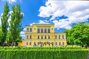 Prague, Czech Republic, May 13, 2019 Yellow Zofin palace Neo-Renaissance building, green trees photo