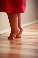 Baby Feet Stretching on Wooden Floor photo