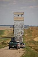 elevador de granos que se mueve a lo largo de la carretera rural de saskatchewan foto
