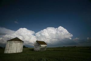 Storm clouds behind old Saskatchewan granaries photo