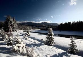 Snow covered road following a river photo