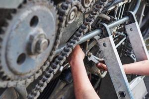 Combine machine service, mechanic repairing motor outdoors photo