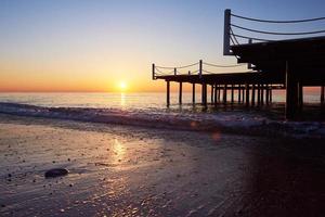 Wooden pier on a fancy orange sunset. photo