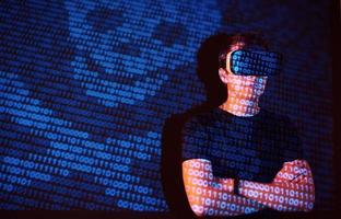 Double exposure of a caucasian man and Virtual reality headset is presumably a gamer or a hacker cracking the code into a secure network or server, with lines of code photo
