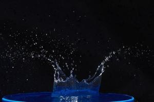 Splash of water crown on blue surface. photo