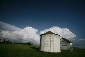 Storm clouds behind old Saskatchewan granaries photo