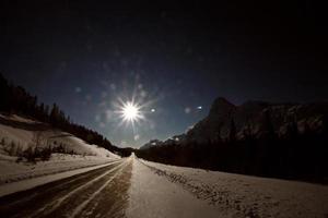 Sun glare down winter road photo