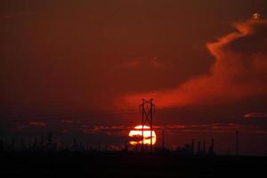Sun setting behind Regina Oil Refinery in Saskatchewan photo