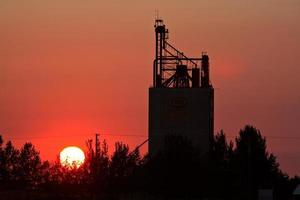 Sun setting behind Eyebrow grain terminal in Saskatchewan photo