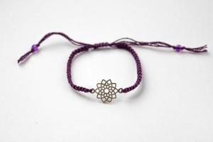 purple braded bracelet with chakra sahasrara on white background photo