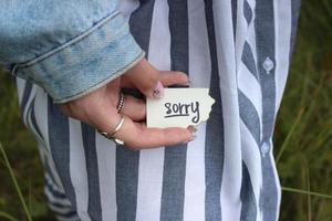 hand of a girl with a note of apology photo