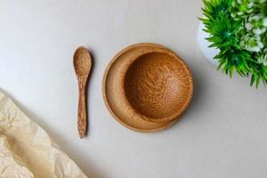 utensilios de madera en la mesa de la cocina. platos redondos, una cuchara, una planta verde. el concepto de servir, cocinar, cocinar, detalles interiores. vista superior foto