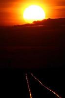 Setting sun shining on railroad tracks photo