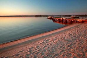 Beach and dock along shore of Lake Winnipeg photo