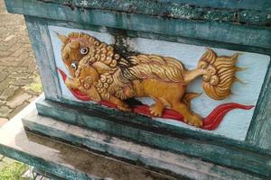 yellow lion carving on the wall photo