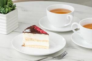 cake in a plate and a cup on the table photo