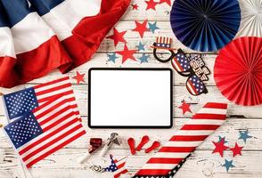 Digital tablet with white screen surrounded with independence day party elements top view flat lay photo