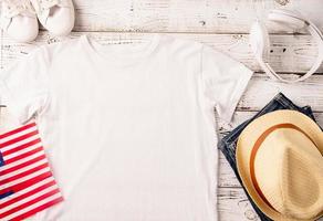 Mockup design white t shirt for logo, top view on white wooden background with US flag and decoration photo