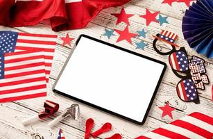 Digital tablet with white screen surrounded with independence day party elements photo