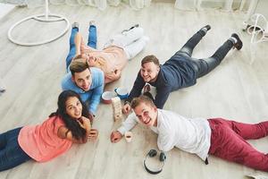 Top view creative photo of friends sitting at wooden table. Friends having fun while playing board game