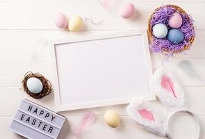 White frame with easter decorations flat lay on beige background photo