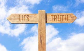 Lies or Truth concept. Wooden signpost with message on sky background photo