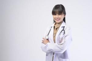 Young female doctor with stethoscope over white background photo