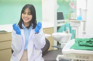 Young female dentist holding invisalign in dental clinic, teeth check-up and Healthy teeth concept photo