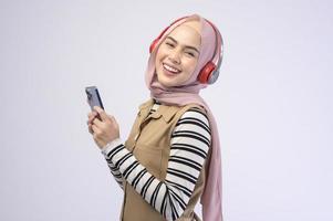 Young beautifu musliml woman wearing headset on white background photo