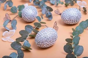 Close-up of easter shiny egg with eucalyptus, butterflies. easter still life photo