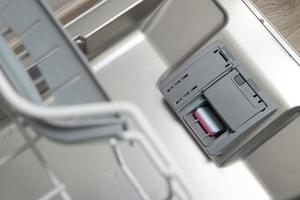 compartimento para detergente con una pastilla en el lavavajillas foto