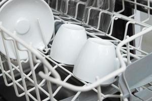 White dishes in the dishwasher. Homework with dishwasher concept photo