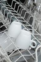 platos blancos en el lavavajillas. tarea con concepto de lavavajillas foto