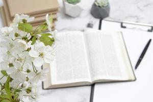 cereza floreciente en el fondo de una biblia abierta en el escritorio foto