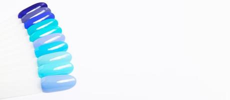 Color palette with blue nail gel polishes for manicure on a white background. Banner format with copy space photo
