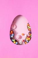 Chocolate easter eggs and decor flat lay for kids easter hunt egg concept on pink background. Sweets in the shape of an egg photo