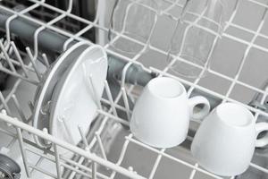 platos blancos en el lavavajillas. tarea con concepto de lavavajillas foto
