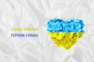 gloria a ucrania, gloria a los héroes texto en ucraniano con corazón de flores en color amarillo y azul de la bandera nacional ucraniana foto