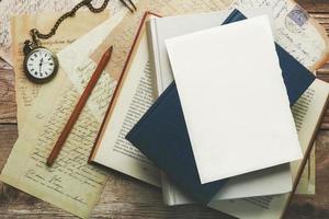 White writing sheet with copy space on top of books and postcards photo