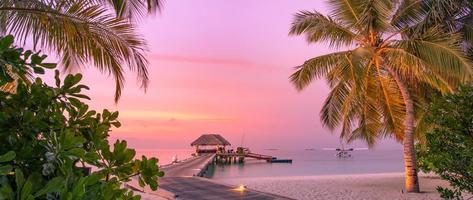 Tranquil panoramic sunset beach scene. Colorful sky and clouds view with calm sea and relaxing tropical mood photo