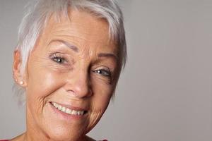 close-up senior woman with toothy smile photo