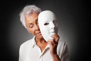 anciana escondiendo la cara triste detrás de la máscara foto