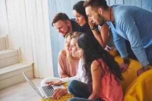 grupo de jóvenes amigos creativos que cuelgan el concepto de redes sociales. personas juntas discutiendo proyectos creativos durante el proceso de trabajo, jugando juegos o viendo películas de video foto