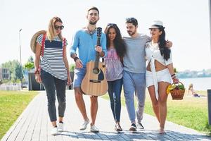 Portrait of group of friends going to on the beach. Mixed group of friends walking on the beach on summer day photo