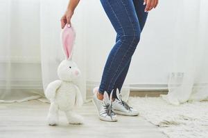 Happy easter. Beautiful sexy young woman wearing bunny ears on shoes and holding cute bunny toy photo