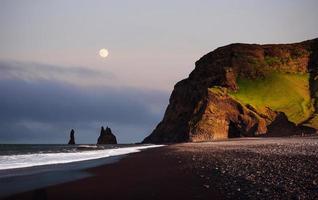 famosas formaciones rocosas de reynisdrangar en la playa negra de reynisfjara. costa del océano atlántico cerca de vik, sur de islandia foto