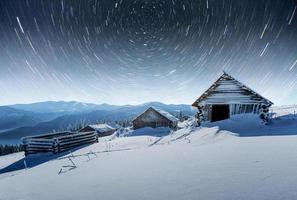 chalets in the mountains at night under the stars. Magic event in frosty day. In anticipation of the holiday. Dramatic scenes photo