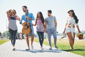 Portrait of group of friends going to on the beach. Mixed group of friends walking on the beach on summer day photo