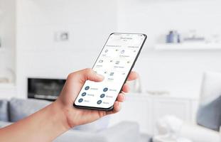 Home automation app controls home devices with smart phone concept. Living room in background photo